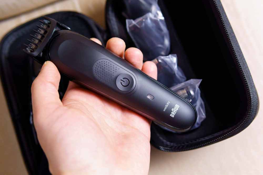 Ein Mann hält einen elektronischen Rasierer von Braun in seiner Hand